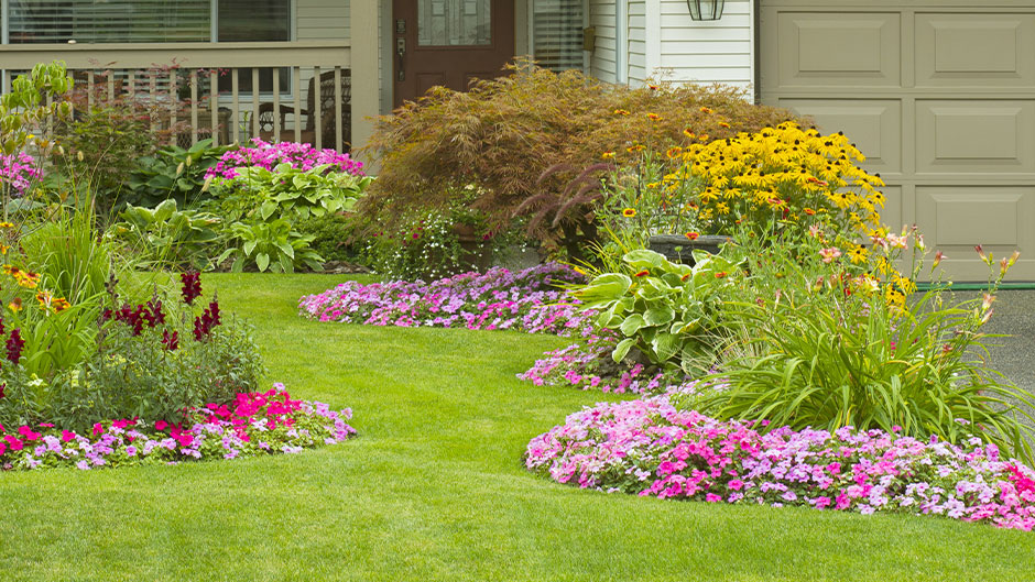 Lawn with beautiful flower beds and home in the background