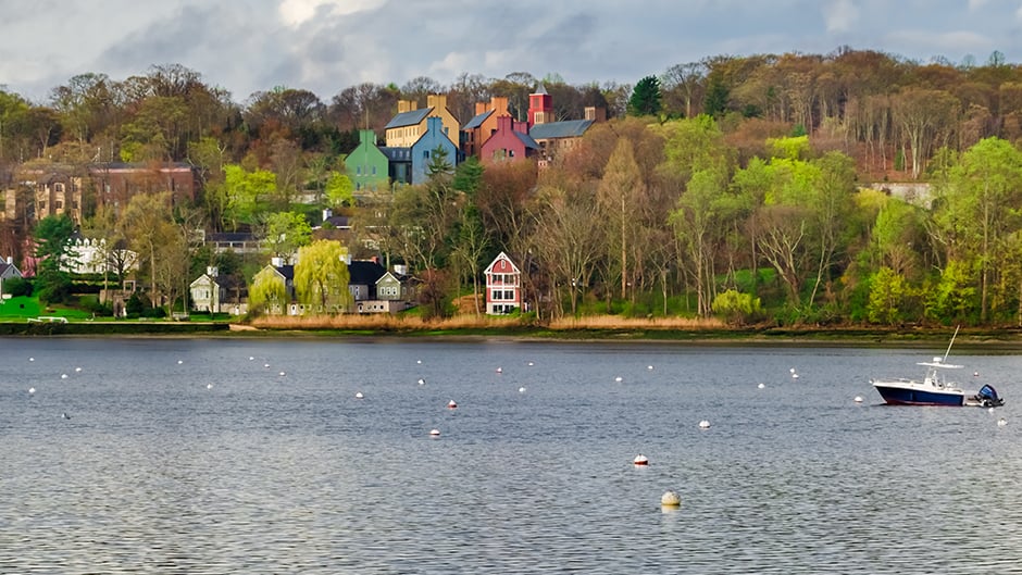 Lake with boat and colorful house across the way