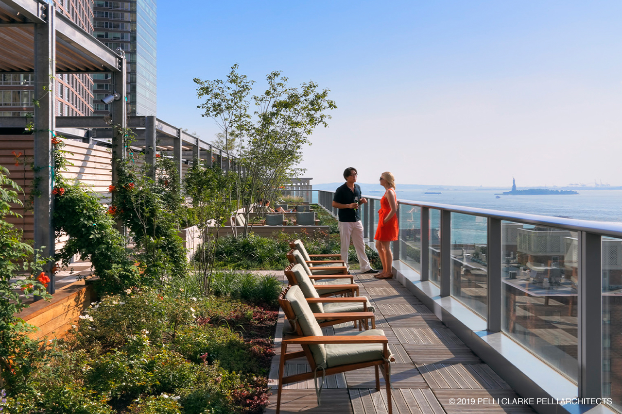 Green roof plant gardens on balcony with couple talking in background