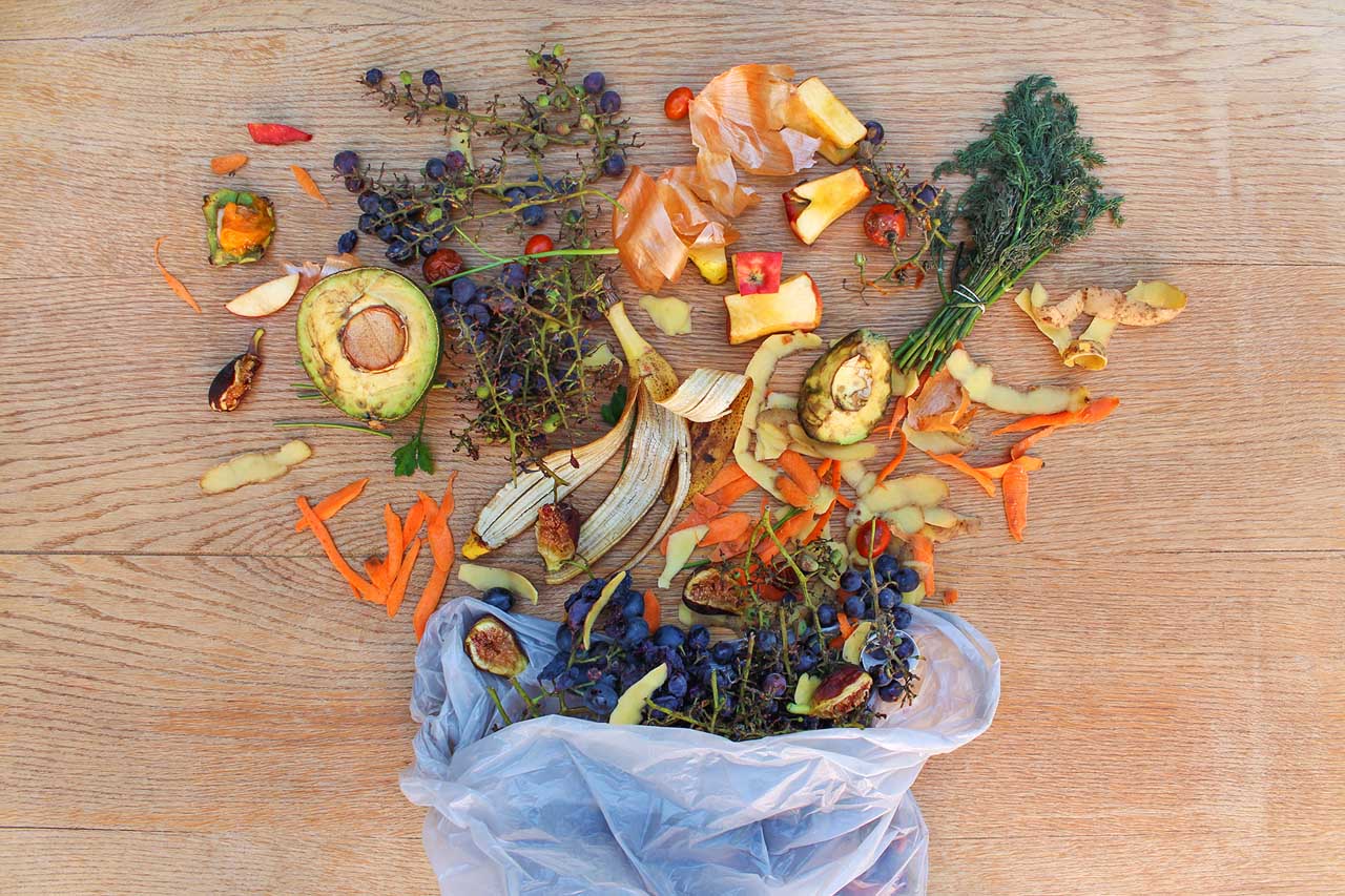 Top view of food waste from fruits and vegetables in the garbage bag on a wooden table