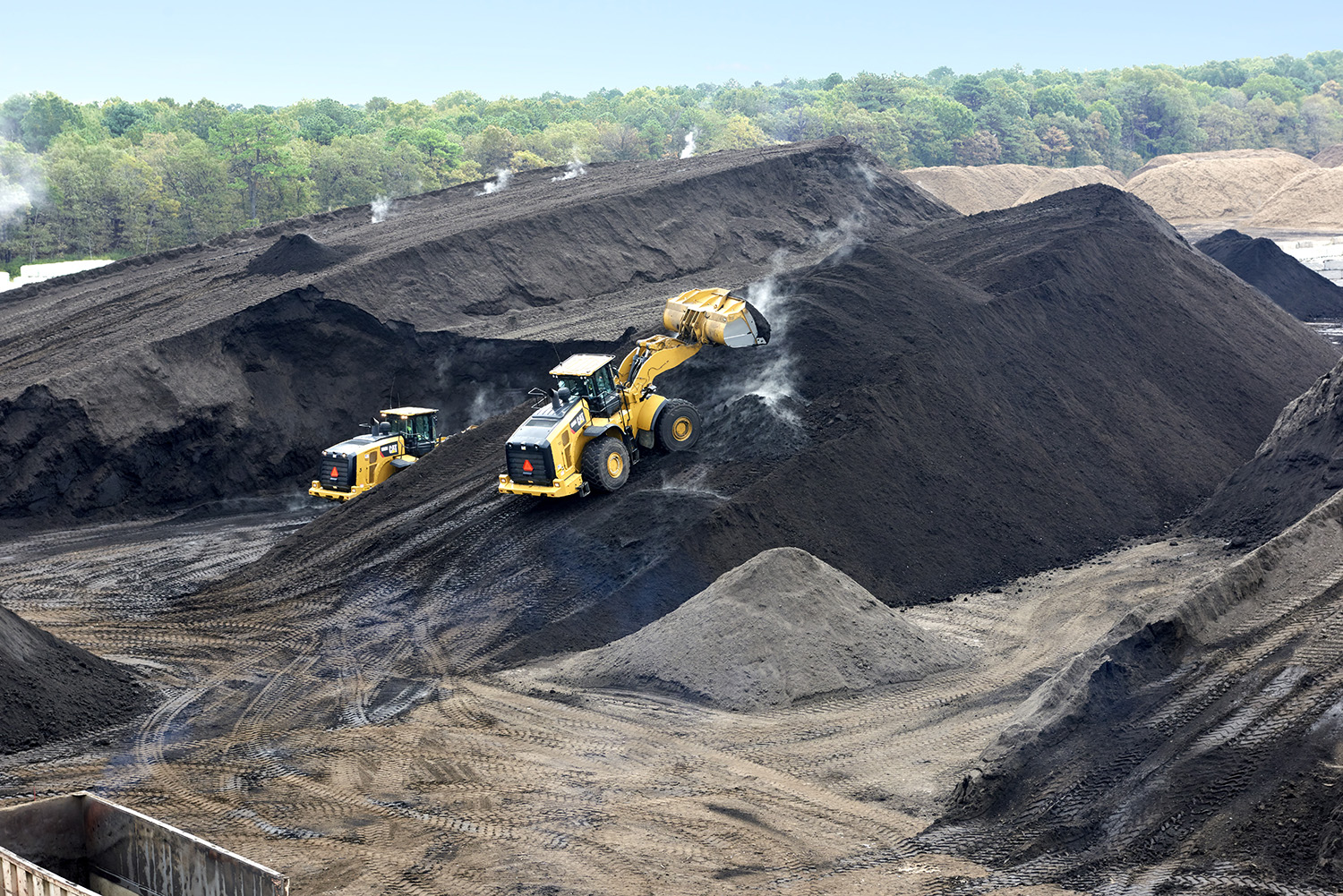 Construction equipment climbing giant hills of soil